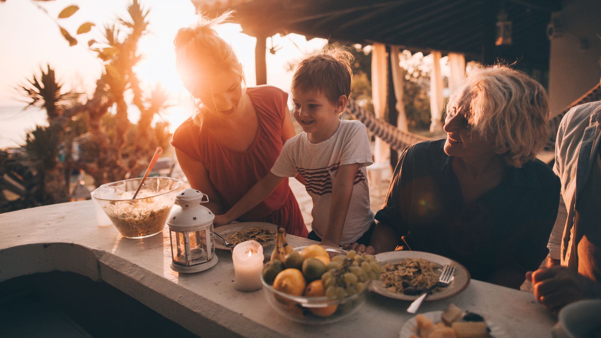 Una famiglia si gode la cena nel loro giardino al tramonto dopo una disinfestazione zanzare VCO